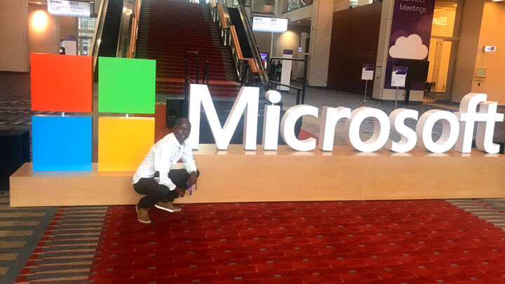 A man standing behing the Microsoft logo